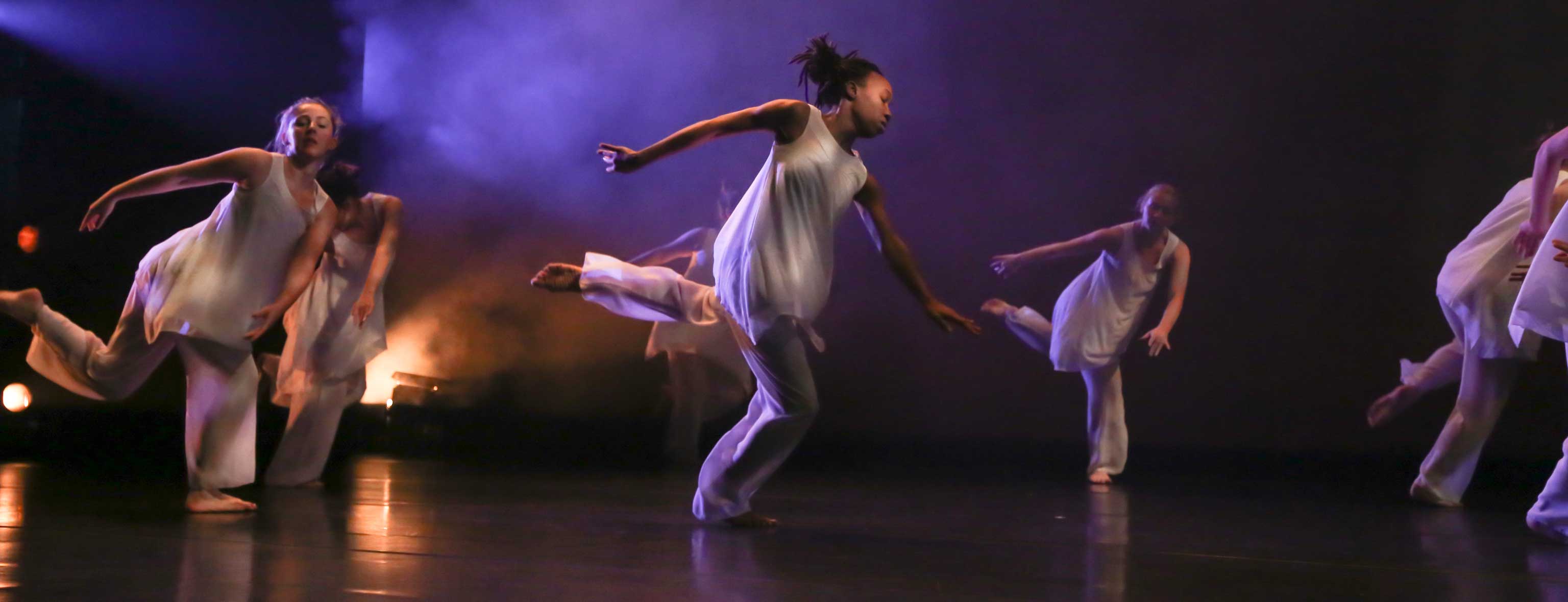 Dancers highlighted with dramatic lighting.