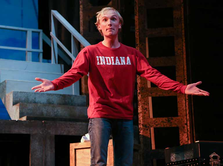 Actor on stage gesturing with hands out